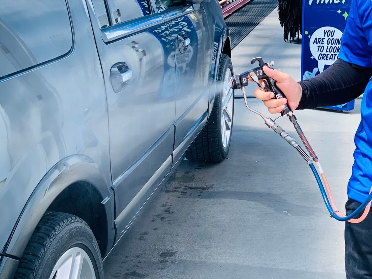 A Buff-N-Shine team member applying specially formulated spray wax by hand